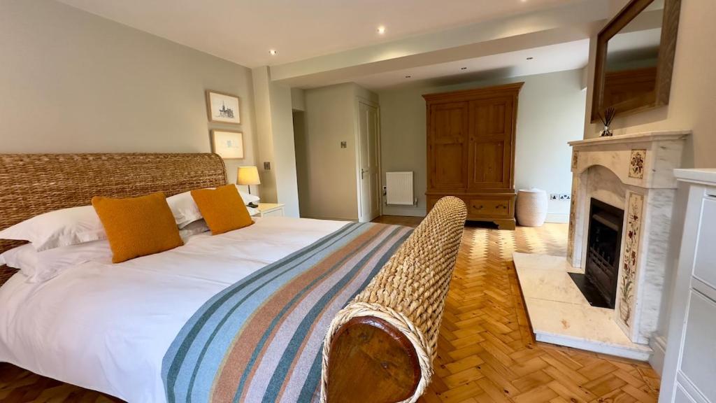 Salisbury Garden Apartment 3 beds 2 baths في Shrewton: غرفة نوم مع سرير كبير ومدفأة