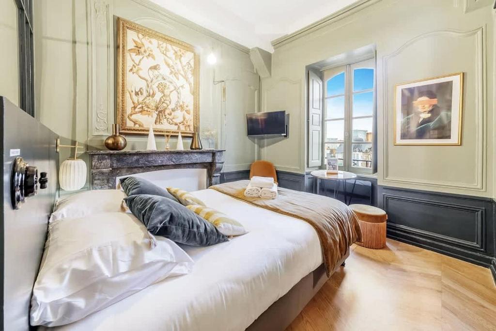 une chambre avec un grand lit blanc avec une fenêtre dans l'établissement L’Augustine, appartement atypique, hyper centre, à Rennes