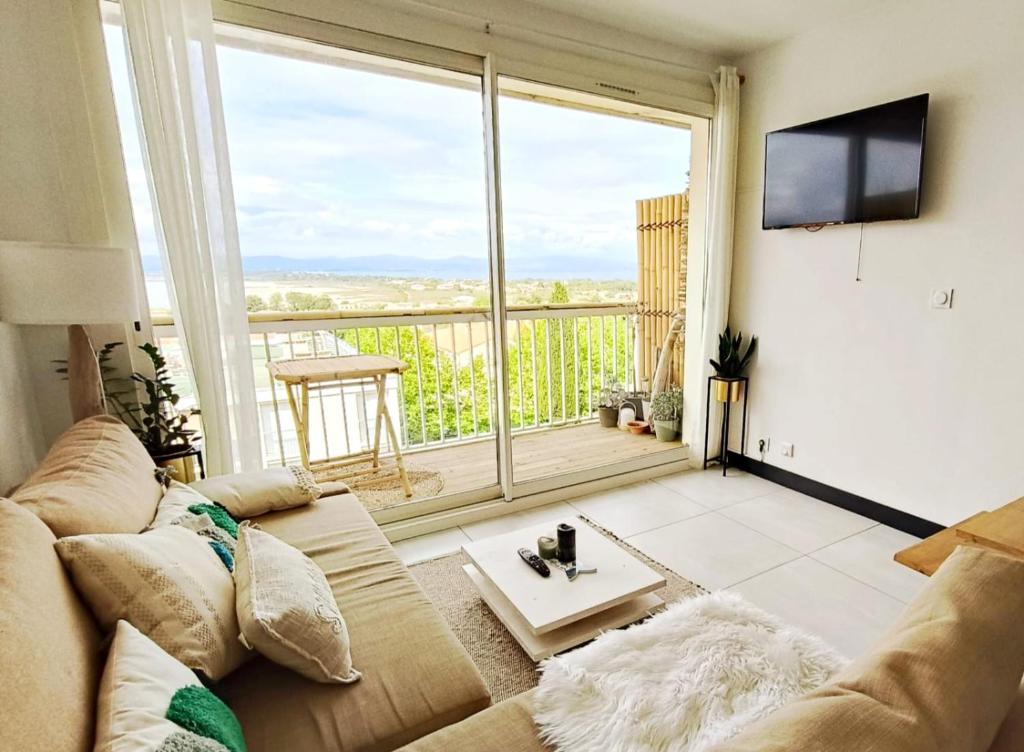 un salon avec un canapé et une grande fenêtre dans l'établissement Cocon vue mer sur Presqu'île, à Hyères