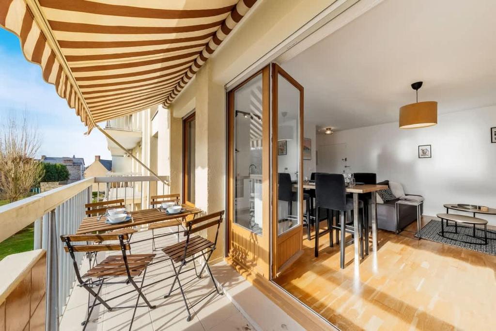 une chambre avec un balcon avec une table et des chaises dans l'établissement Le Frida - T2 rénové - Balcon- 500m centre, à Dinard
