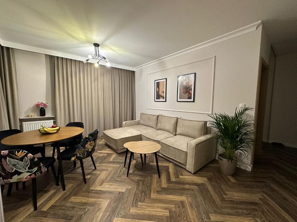 a living room with a couch and a table at Apartament GB przy PCK 3 z bezpłatnym parkingiem by Gingerbread Apartments in Toruń