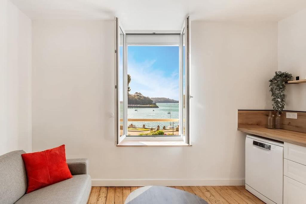 - un salon avec une fenêtre donnant sur la plage dans l'établissement Le Solidor - Vue mer - Joli pied à terre rénové, à Saint-Malo