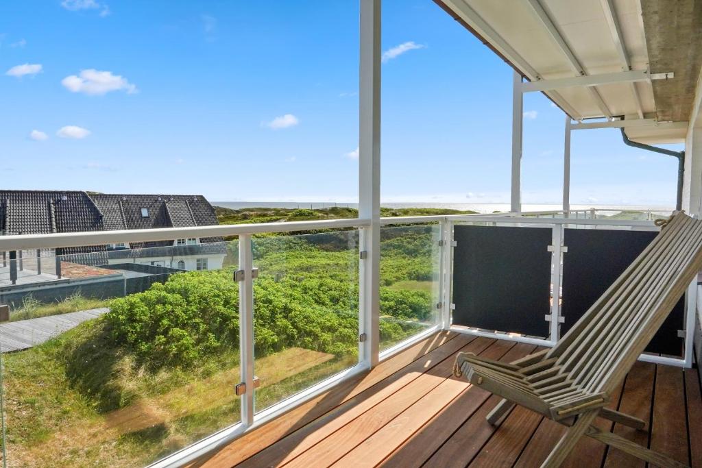 a room with a balcony with two chairs on a deck at Gurtdeel Meerluft-Suite in Hörnum