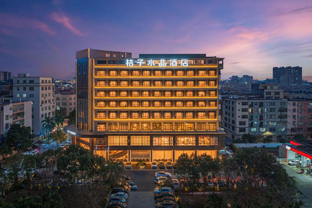 a lit up building in a city at dusk at Yangjiang Jiangcheng Jinshang Road Orange Crystal Hotel in Yangjiang
