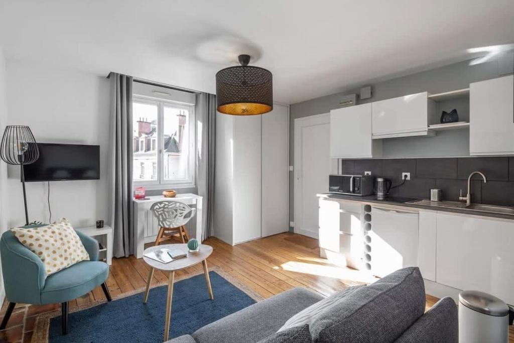 un salon avec un canapé et une cuisine dans l'établissement Le Descartes emplacement idéal - Gare centre, à Rennes