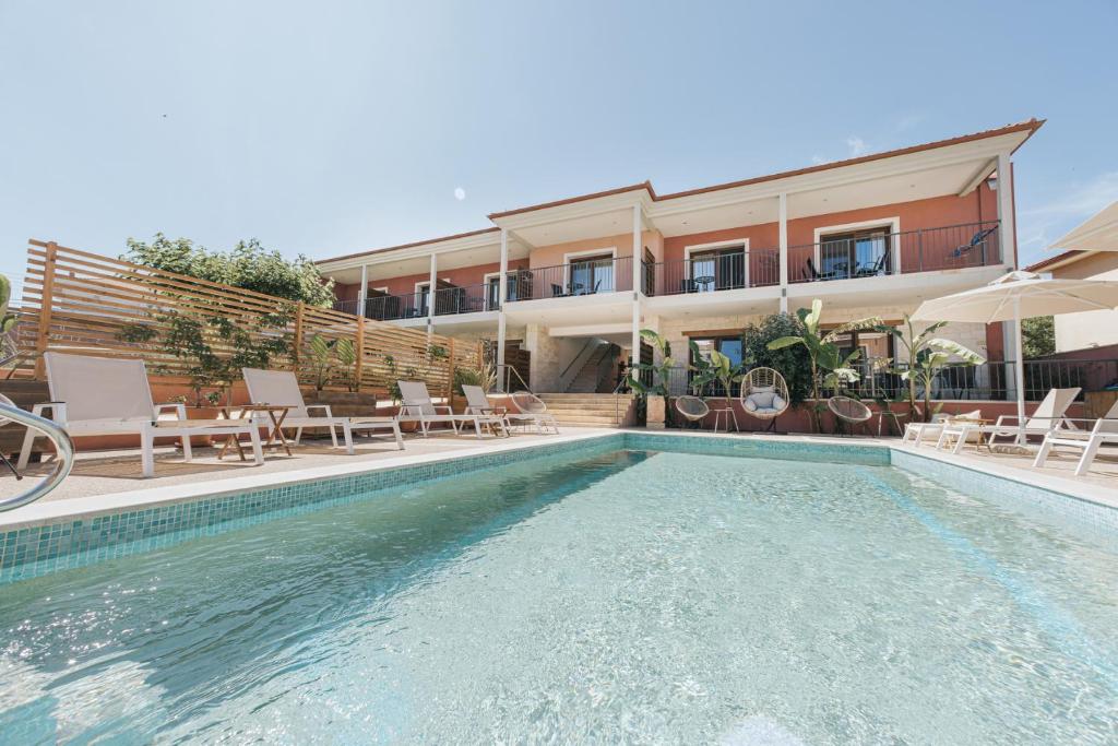a hotel with a swimming pool in front of a building at Samari Afitos in Afitos