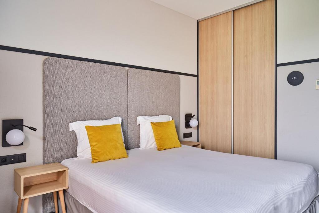 Postel nebo postele na pokoji v ubytování Appart'hôtel Odalys City - Bioparc Lyon Est