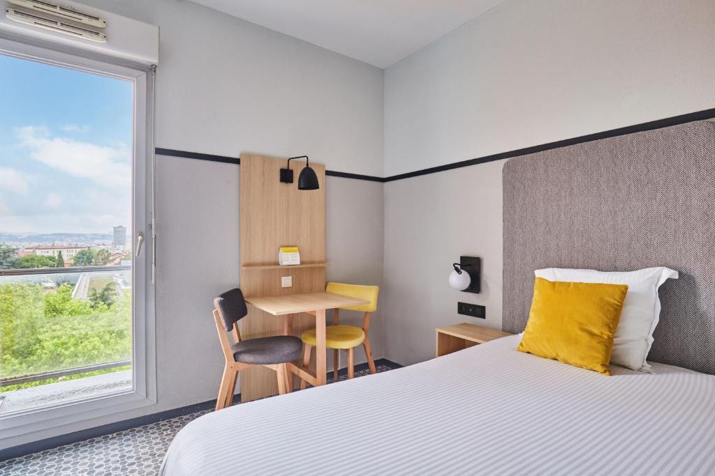 Postel nebo postele na pokoji v ubytování Appart'hôtel Odalys City - Bioparc Lyon Est