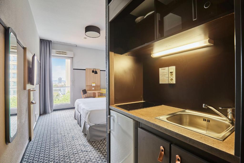 Postel nebo postele na pokoji v ubytování Appart'hôtel Odalys City - Bioparc Lyon Est