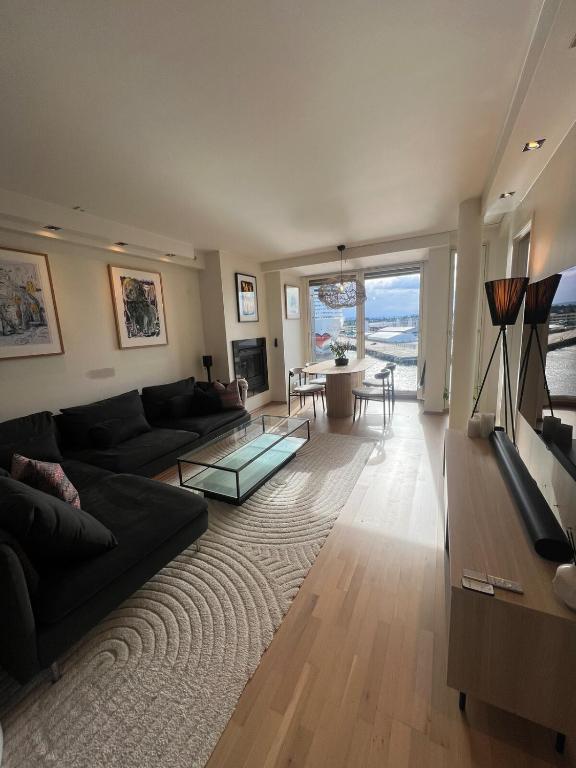 a living room with a couch and a glass table at Spacious apartment with sea-view and sunset in Oslo