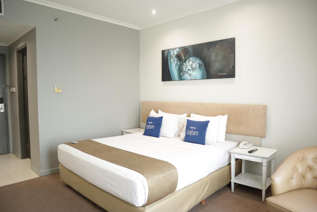 Postel nebo postele na pokoji v ubytování Hotel Dafam Semarang