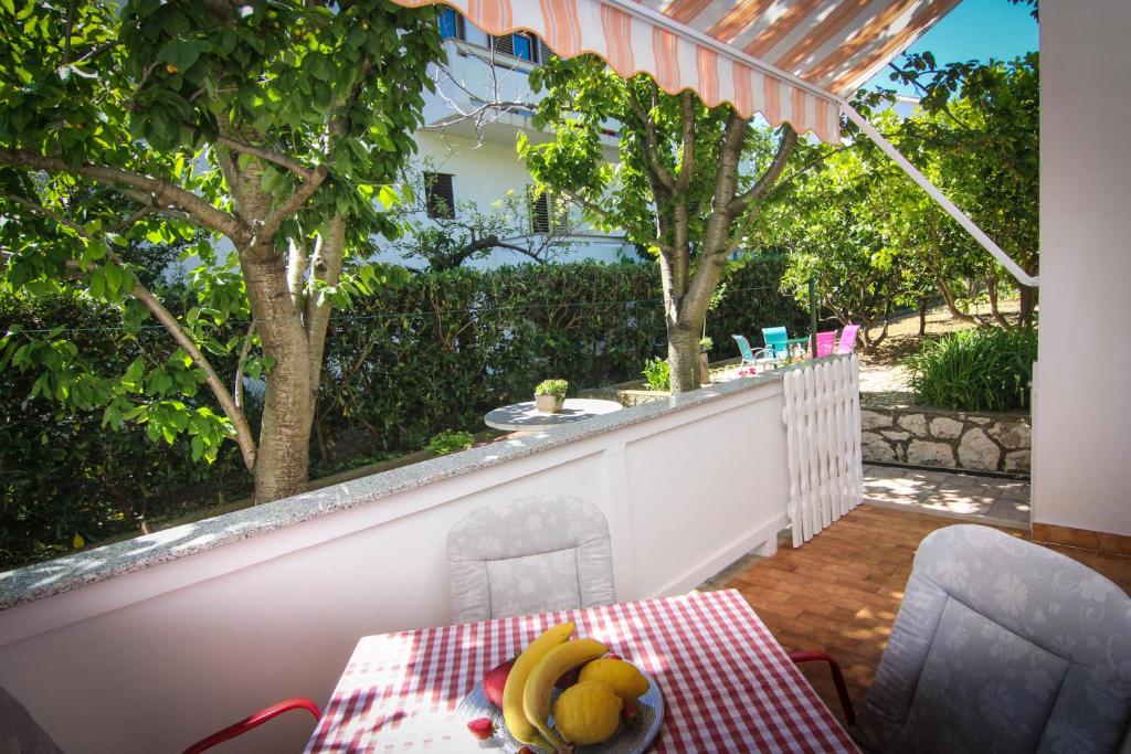 a table with a bowl of fruit on a balcony at Apartments Biserka G in Palit