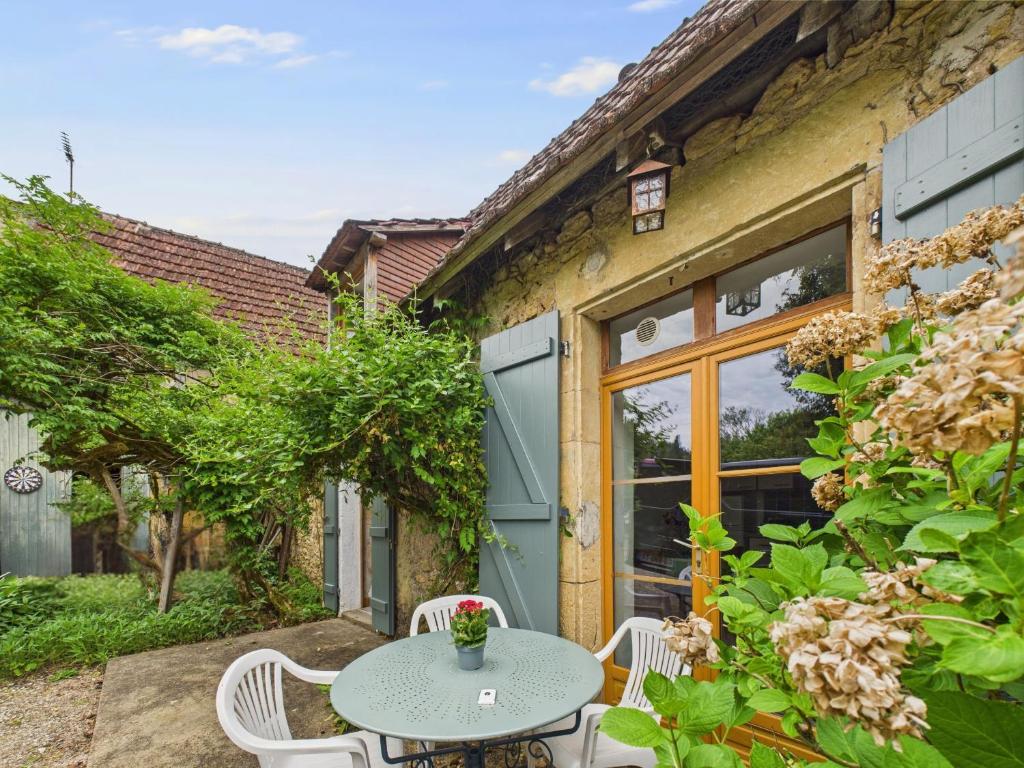 a patio with a table and chairs in front of a building at Piscine et domaine arboré partagés - maison pour 4 in Montignac
