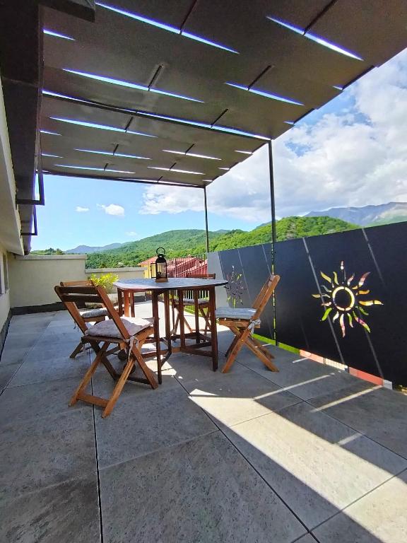 a patio with a table and chairs on a roof at La casa di Ottavio in Giaveno