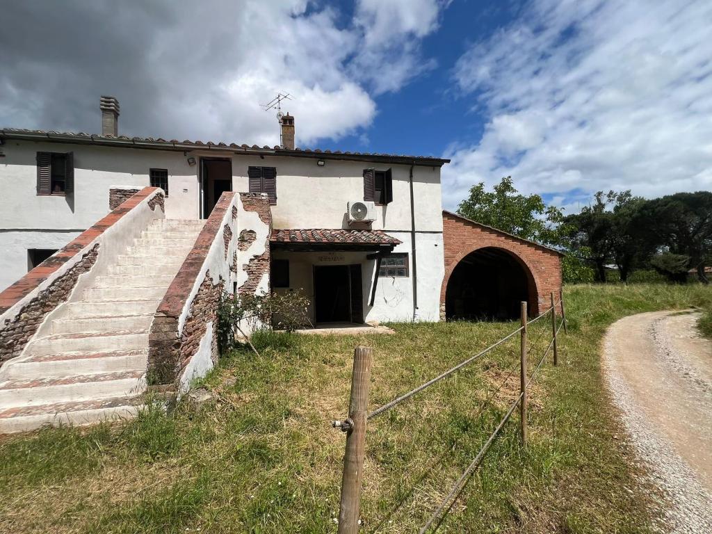 ein altes weißes Gebäude mit einem Tor und einem Tunnel in der Unterkunft Quattro stagioni appartamento Inverno in Castiglione del Lago