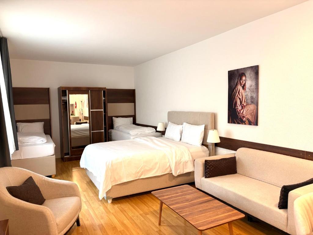 a hotel room with a bed and a couch at Akomo Bern in Bern