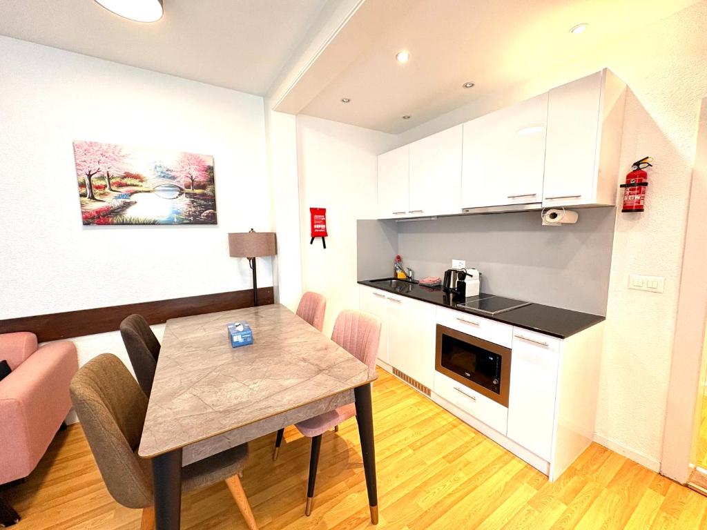 a kitchen and a dining room with a table in a room at Akomo Bern in Bern