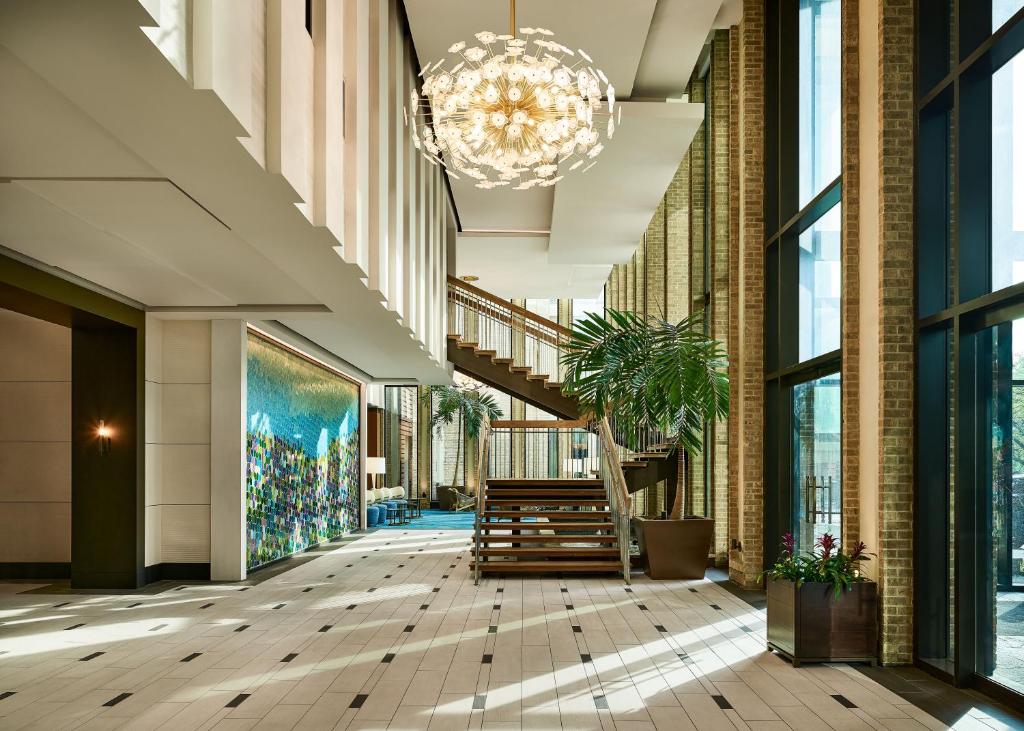 a lobby with a staircase and a chandelier at The Highland Dallas, Curio Collection by Hilton in Dallas