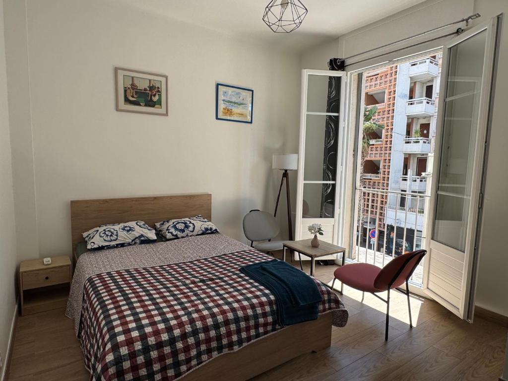une chambre avec un lit, une chaise et une fenêtre dans l'établissement Charming apartment in Toulon, à Toulon