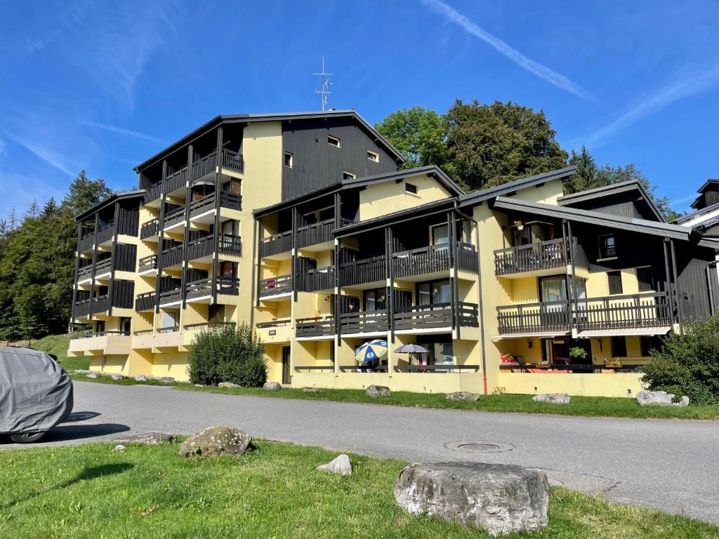 ein gelbes Apartmenthaus mit Balkonen auf einer Straße in der Unterkunft Appartement Les Airelles in Arâches-la-Frasse