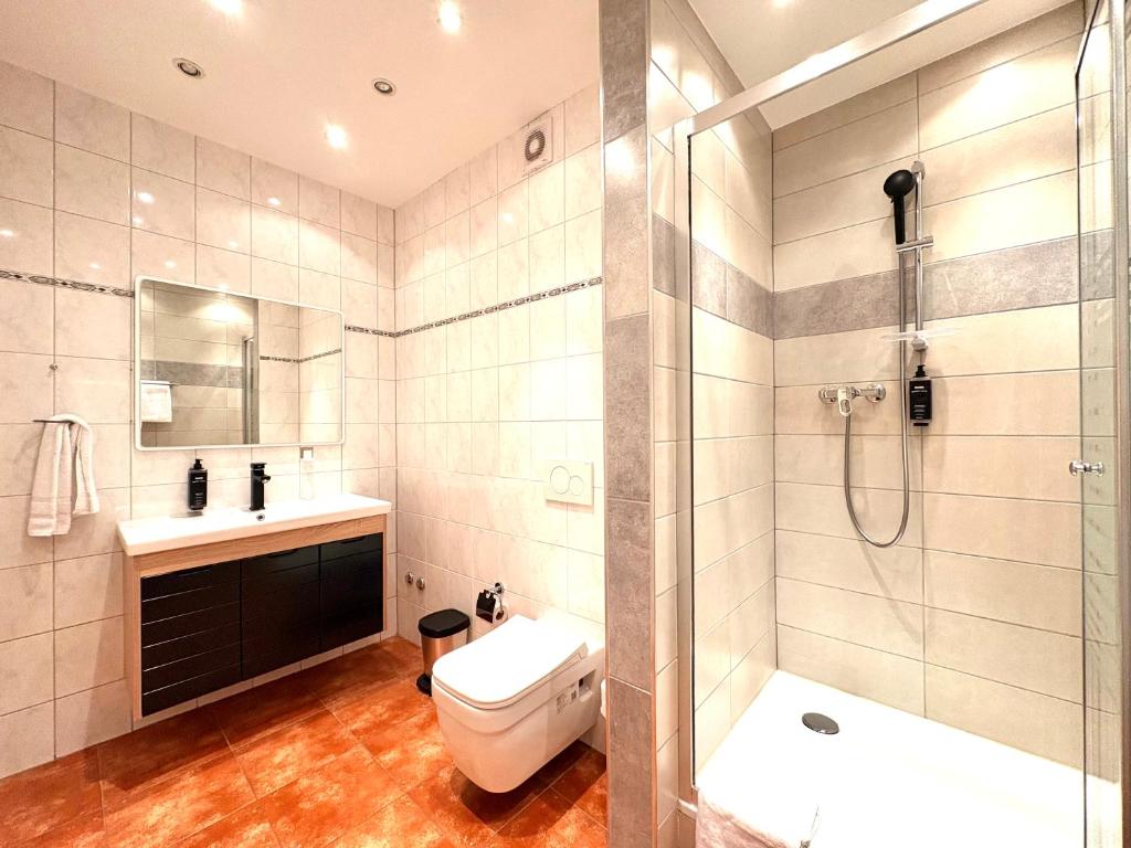 a bathroom with a shower and a toilet and a sink at Akomo Bern in Bern