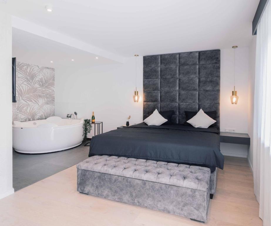 a bedroom with a large bed and a bath tub at Boutiquehotel Reuter GmbH in Hattingen