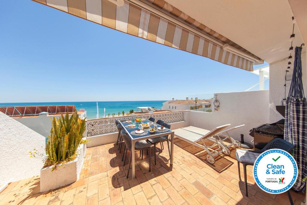 a patio with a table and a view of the ocean at Beco do Poço Beach Townhouse in Praia da Luz in Luz