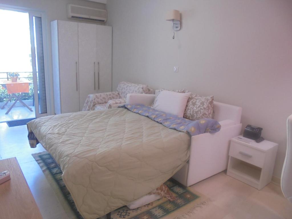 a bedroom with a bed and a chair in it at Modern Studio by the sea in Loutra Edipsou