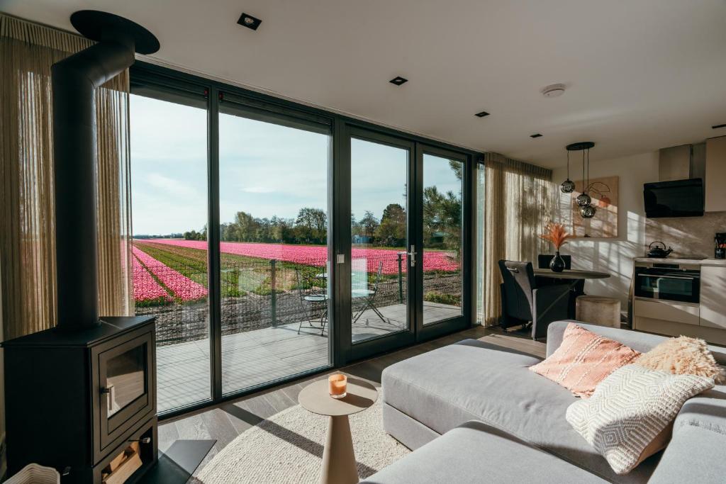 een woonkamer met uitzicht op een tulpenveld bij Bos, duin en strand huisje in Noordwijk