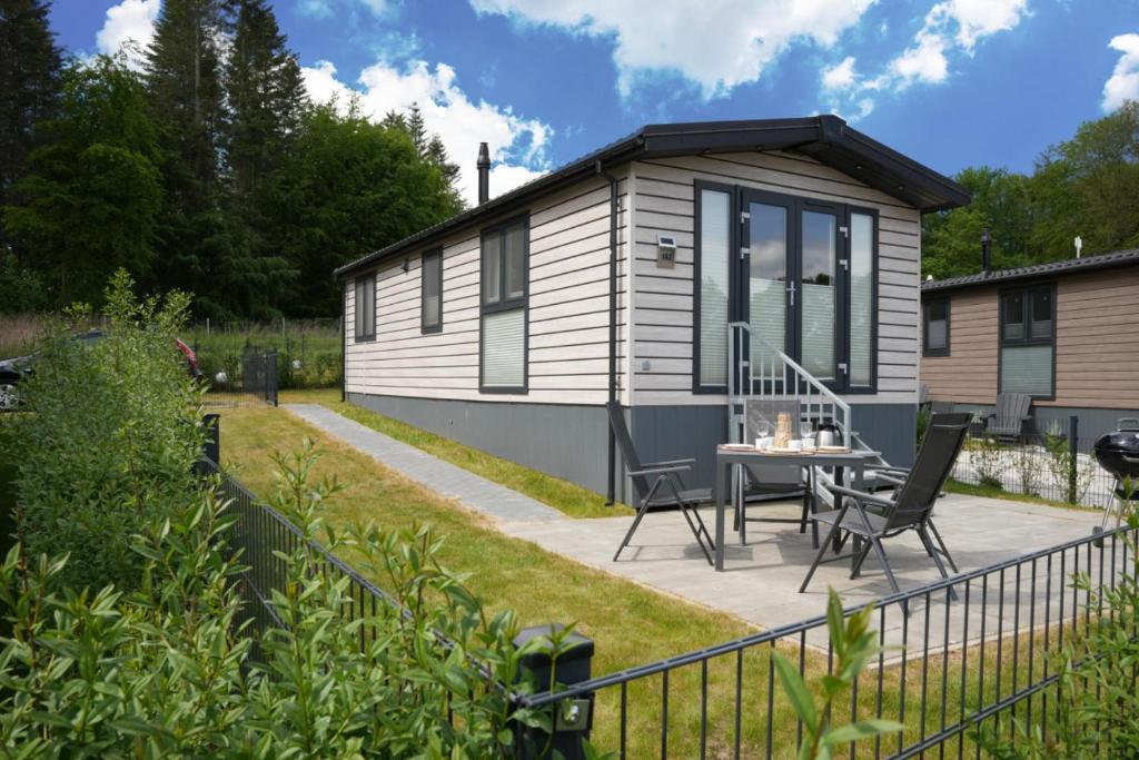a tiny house with a patio and a table at Ostseecamp Ferienhaus "KleineDüne" in Scharbeutz