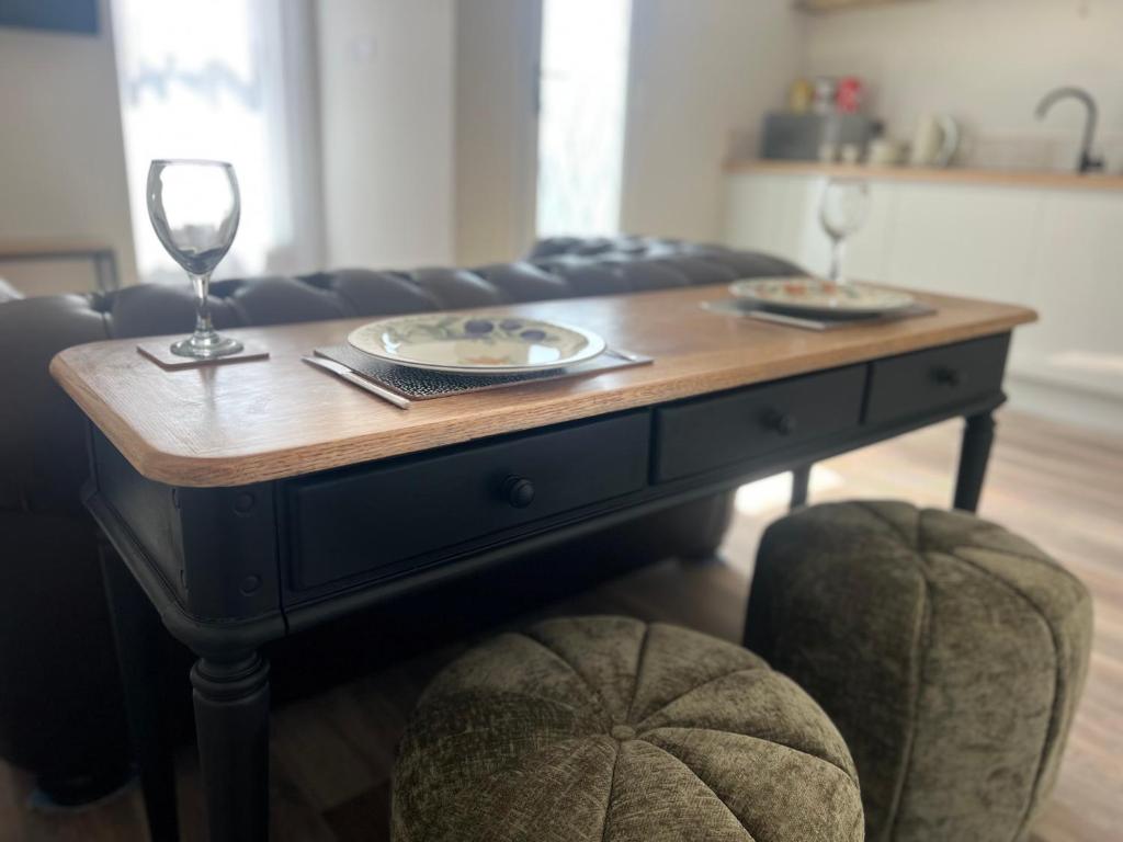 ein Holztisch mit zwei Tellern und Weingläsern darauf in der Unterkunft roof tops apartment in Ilfracombe