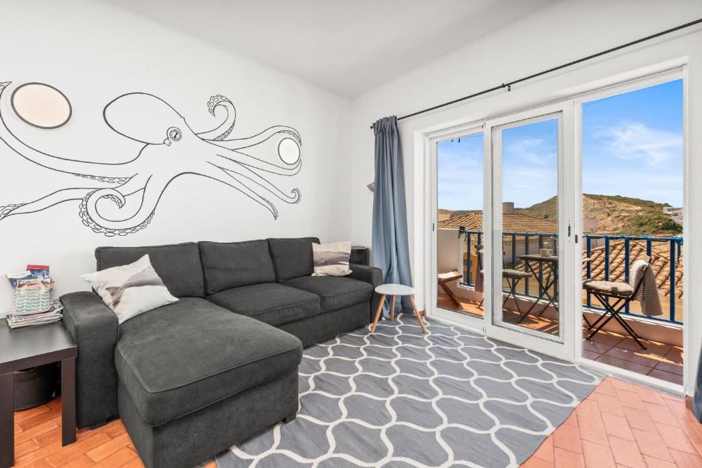 a living room with a couch and an octopus on the wall at Casa Indie in Burgau