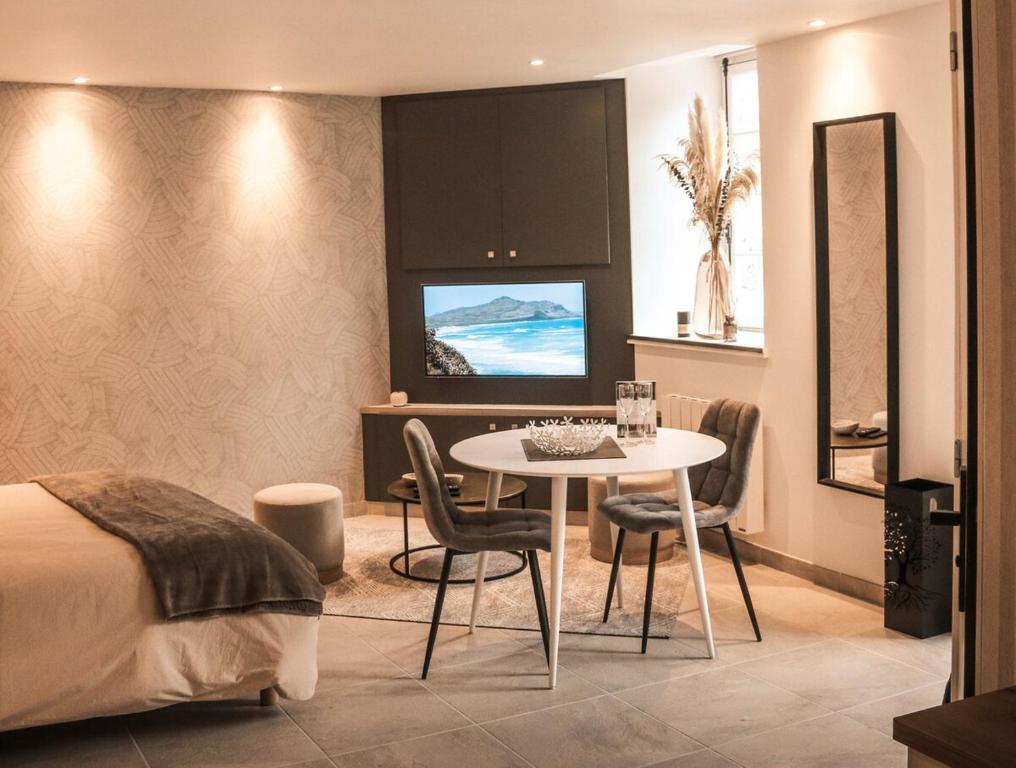 une chambre avec un lit, une table et des chaises dans l'établissement Studio Le Benetin 2 personnes à Dinan, à Dinan