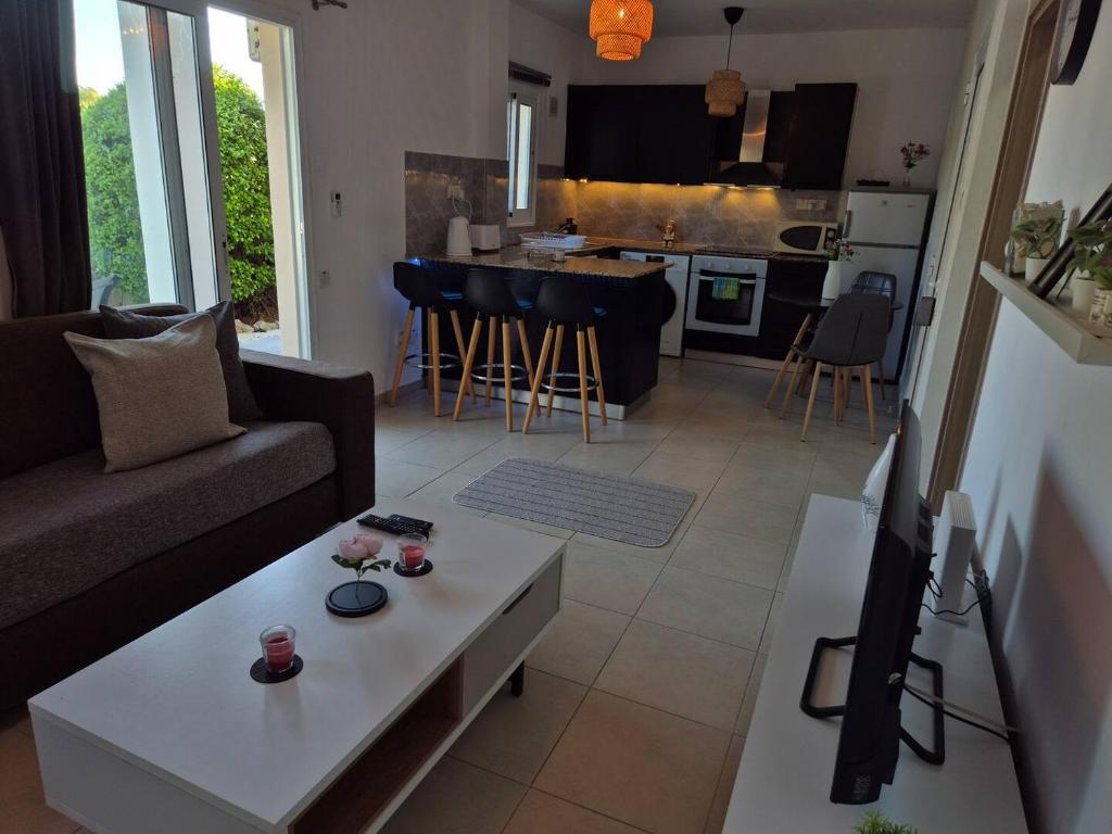 Una sala de estar con un sofá y una mesa de café. en Olymbos Garden Apartment IV, en Ayia Napa