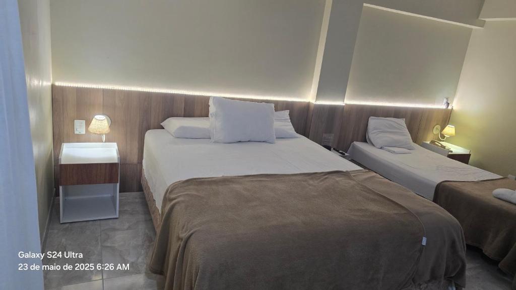 a hotel room with two beds and a night stand at Royal Flat ' Hotel, unidade nº 204 in João Pessoa