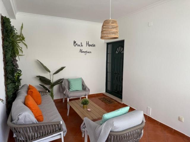 a living room with a couch and a table and chairs at Breeze House Almograve - Casa de Férias T4 in Almograve