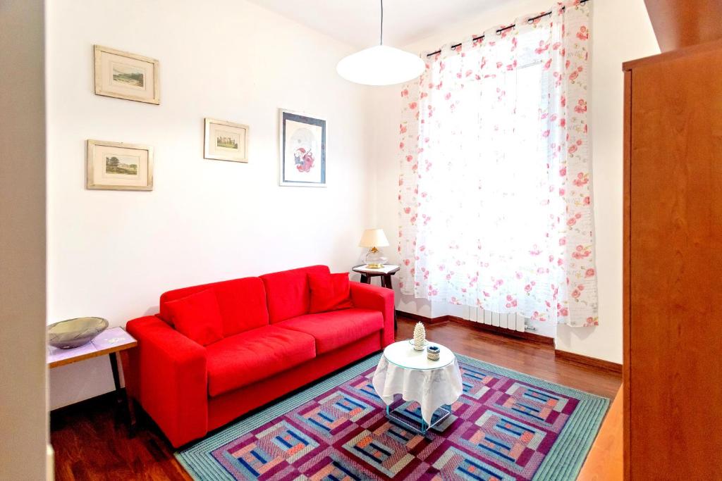 un sofá rojo en una sala de estar con mesa en DomusVaticano, en Roma