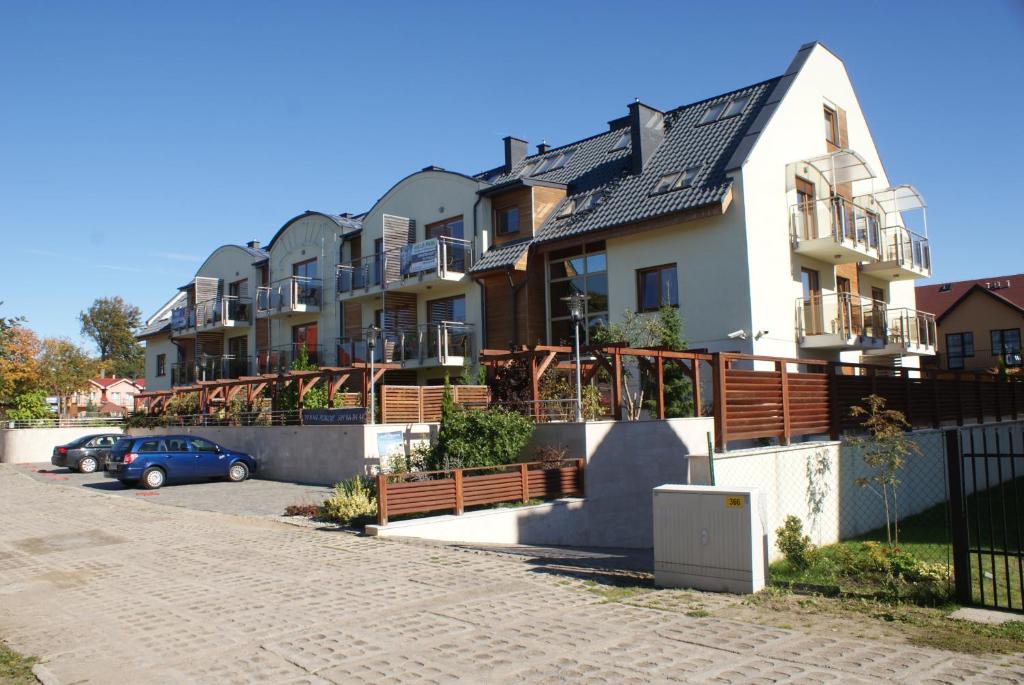 a row of houses with a car parked in front at Baltic Vip Apartamenty blisko morza in Rewal