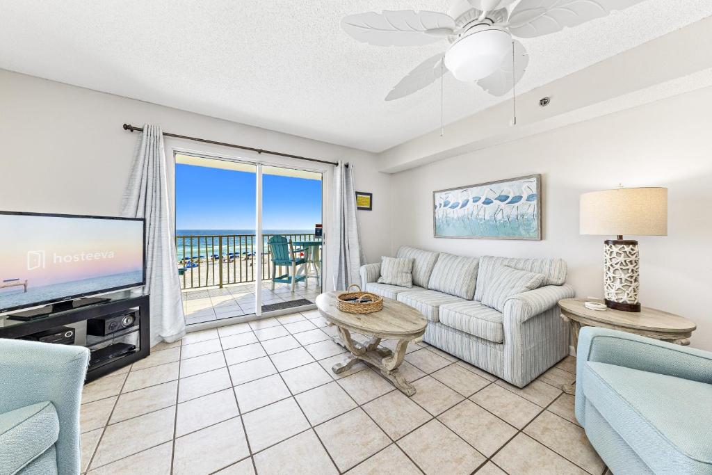 a living room with a couch and a tv at Four Winds 301 in Orange Beach