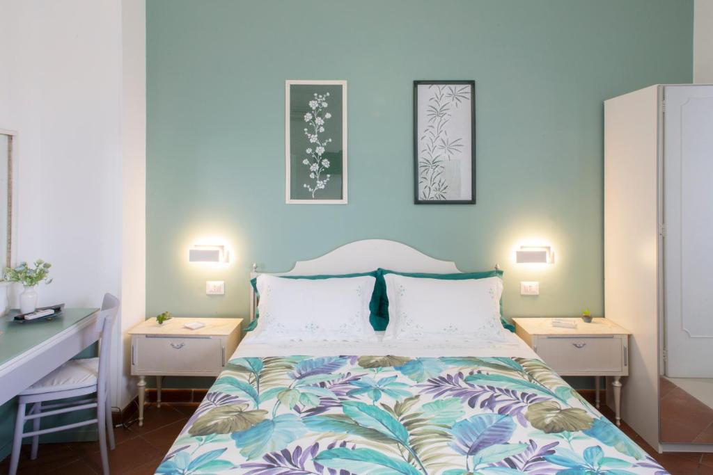 a bedroom with a bed with two night stands and two tables at Domus Liventa B&B in Cursi