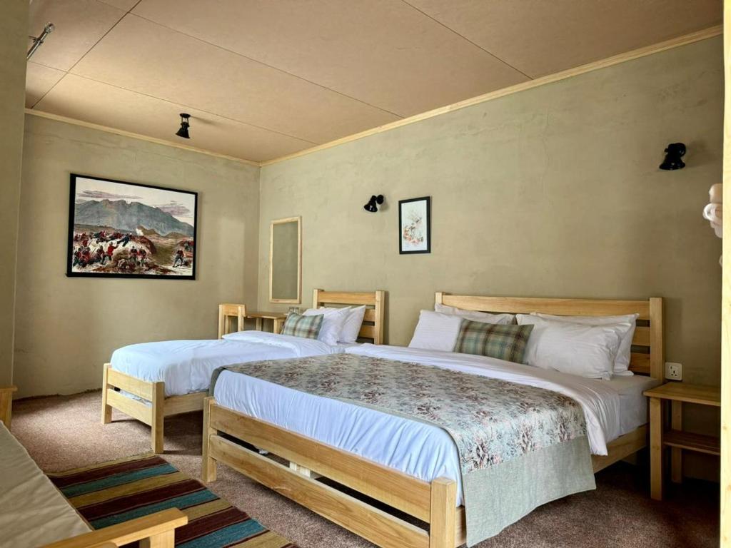 a bedroom with two beds and a couch at Bucolic River Resort in Gulmit