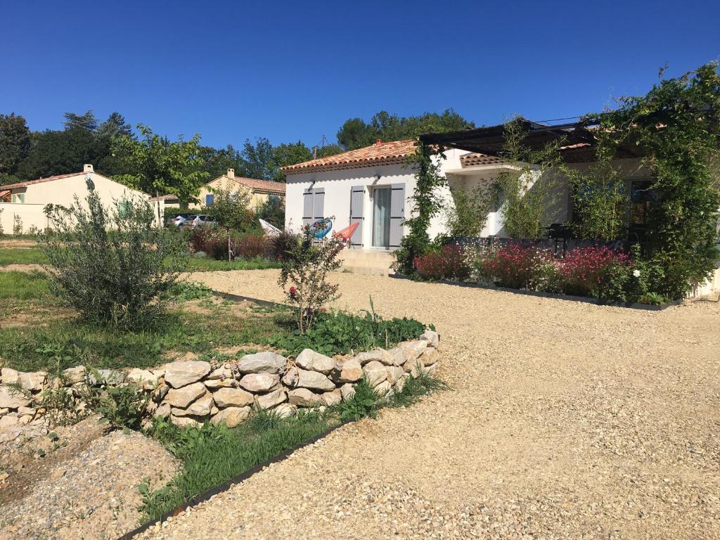 une maison avec un chemin en pierre devant elle dans l'établissement A L'OMBRE DES GLYCINES maison avec piscine 7 personnes, à La Verdière