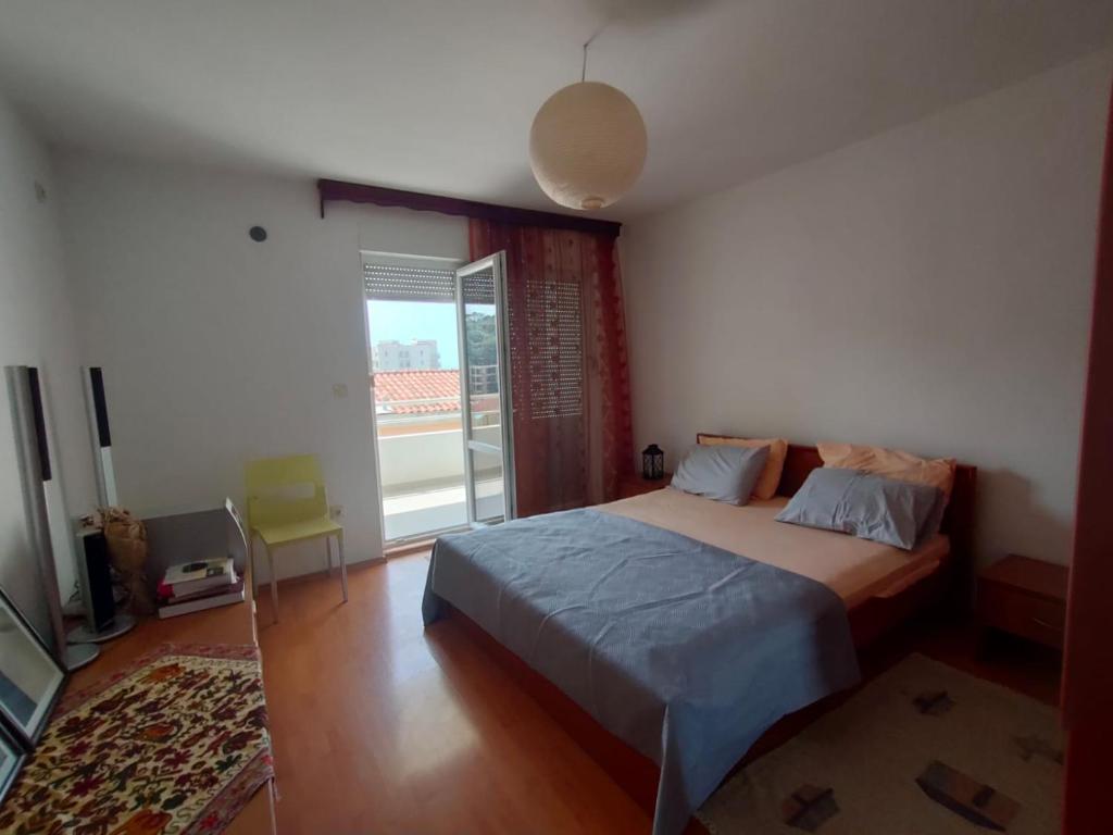 a bedroom with a bed and a large window at MiNa Apartments in Petrovac na Moru