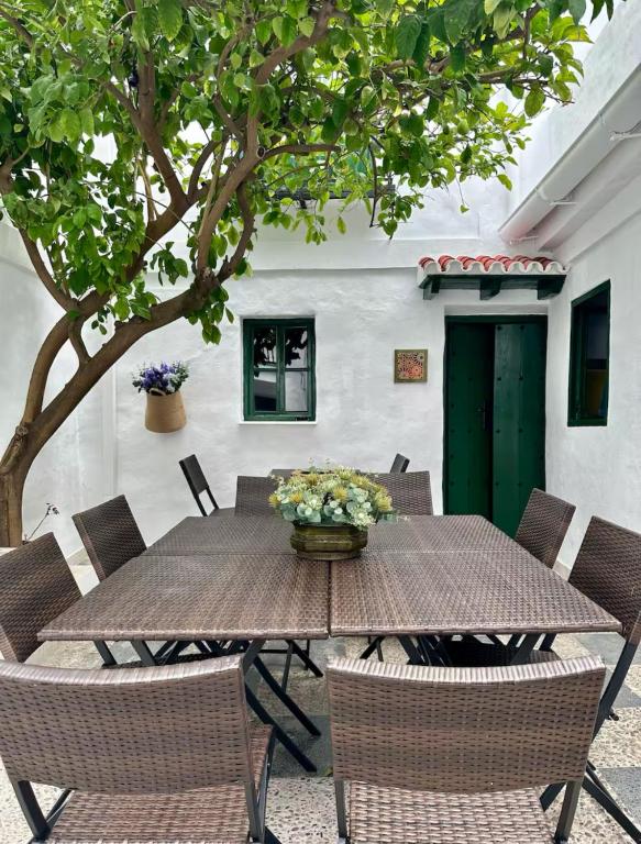 a wooden table with chairs and a vase of flowers at Espectacular Casa Cordobesa in Córdoba