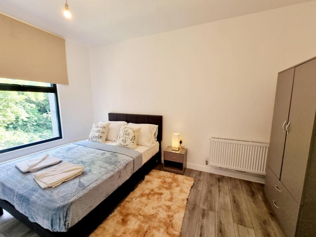 a bedroom with a bed and a window at Woolwich Apartments in London