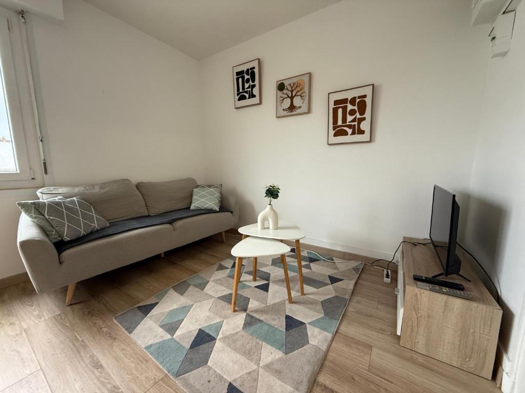 un salon avec un canapé et une table dans l'établissement Studio autonomie et confort - Centre ville Boulogne Sur Mer - Baignoire et lave linge, à Boulogne-sur-Mer