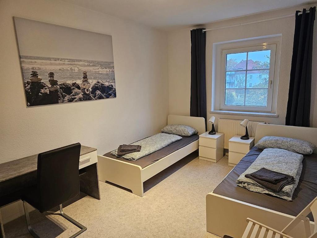 a room with two beds and a window at Leuna bei Leipzig & Halle - 2 Apartments mit je 3 Schlafzimmern, Küche, Bad in Leuna