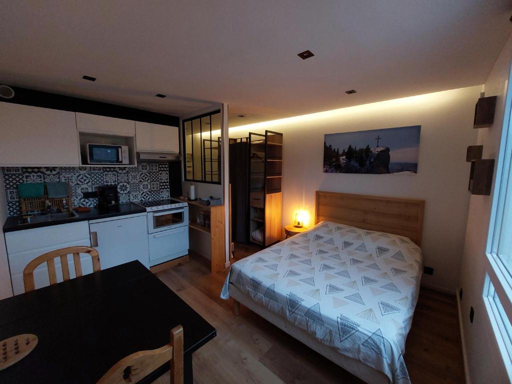 une chambre avec un lit et une cuisine avec une table dans l'établissement Studio, à Chambéry