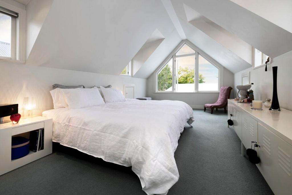 Iconic Villa in the Heart of Ponsonby في أوكلاند: غرفة نوم بيضاء مع سرير كبير ونافذة
