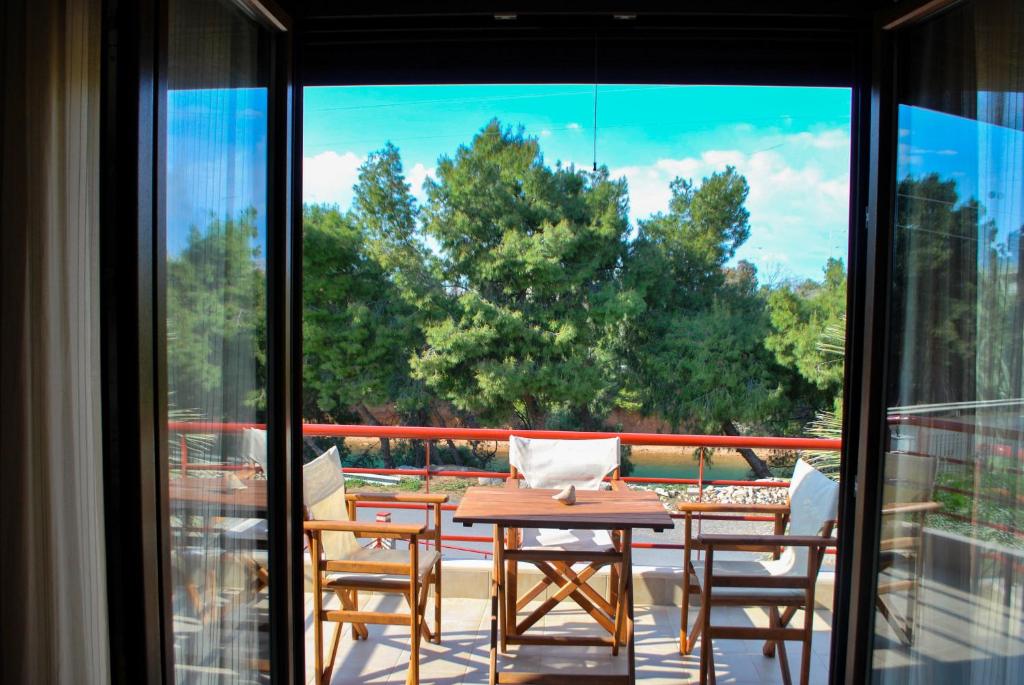 a patio with a table and chairs on a balcony at Canal Luxury Apartments in Nea Potidaea